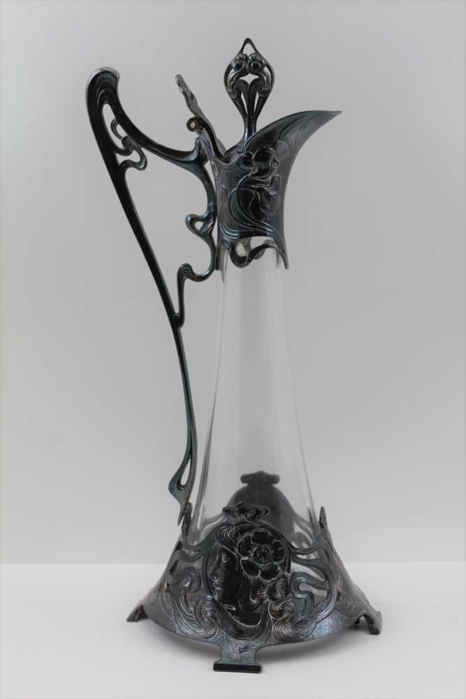 AN ART NOUVEAU DESIGN CLARET JUG, having cast metal decorative mounts in the WMF jugendstil form,