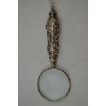 A SILVER HANDLED MAGNIFYING GLASS, the decoratively embossed handle hallmarked Birmingham 1899,