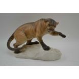 A BESWICK CERAMIC PROWLING MOUNTAIN LION, upon a snow covered rock base, matt finish, printed