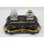 A LATE VICTORIAN PAPIER MACHE STANDISH, with two glass inkwells, the base having pen recess,