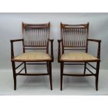 A PAIR OF EDWARDIAN MAHOGANY FRAMED OPEN ARMCHAIRS, outswept sabre supports, with upholstered seats