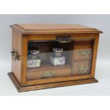 AN EDWARDIAN OAK STATIONERY CABINET with bevelled glass drop front and 'Haida' (Bohemian)