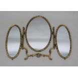 A TRIPLE DRESSING TABLE MIRROR, gilded frame, set three oval plates
