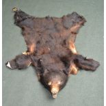 A BLACK BEAR SKIN WITH BLOCKED HEAD