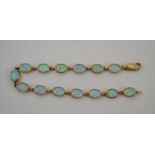 A 9CT GOLD OPAL MOUNTED BRACELET with fourteen oval opal links, length; 19cm (including the clip),