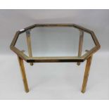 A BRASS FRAMED COFFEE TABLE, irregular octagonal top, inset glass panel, 51cm x 63cm