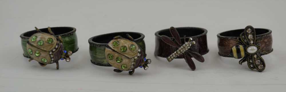A SET OF FOUR CAST METAL ENAMELLED & JEWEL SET NAPKIN RINGS, decorative inset mounts (4)