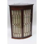 A MAHOGANY WALL HANGING BOW FRONT CORNER CABINET, fitted two astragal glazed doors, 91cm high