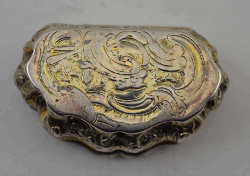 AN 18TH CENTURY PARCEL GILT WHITE METAL CONTINENTAL SNUFF BOX, of Rococo serpentine form, repousse - Image 4 of 5