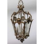 A CAST BRASS HALL LANTERN, cast Art Nouveau mask decoration, of hexagonal form, fitted clear star