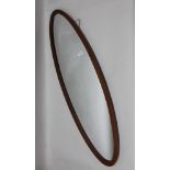 AN OVAL WOODEN FRAMED WALL MIRROR and a decorative brass framed wall mirror (2)