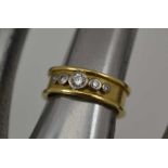 AN 18CT GOLD BAND FORM RING, inset five graduated diamonds, weight; 5.4g, ring size; "H"
