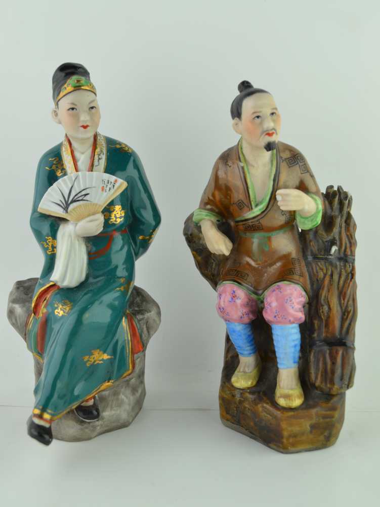 TWO ORIENTAL CERAMIC FIGURES, polychrome decorated, one a seated figure with a fan, the other seated