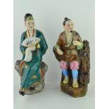 TWO ORIENTAL CERAMIC FIGURES, polychrome decorated, one a seated figure with a fan, the other seated