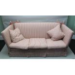 A THREE-SEATER KNOLL STYLE SOFA, fitted three seat cushions, and two scatter cushions, with pink