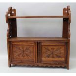 AN EDWARDIAN OAK WALL UNIT, with open shelves and two decorative doors, 64cm wide