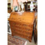 A REPRODUCTION YEW WOOD FINISHED BUREAU of typical form & construction