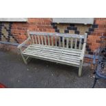 A WELL WEATHERED TEAK SLAT BUILT THREE PERSON GARDEN BENCH