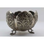 AN EASTERN WHITE METAL BOWL, of lobed form, decorated with birds amidst flowers, raised on three