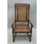 A 17TH CENTURY DESIGN LIGHT OAK DESIGN ARMCHAIR with crown carved crest rail, bergere back and seat,