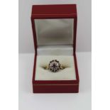 AN 18CT GOLD RUBY & DIAMOND CLUSTER RING, ring size; "M"
