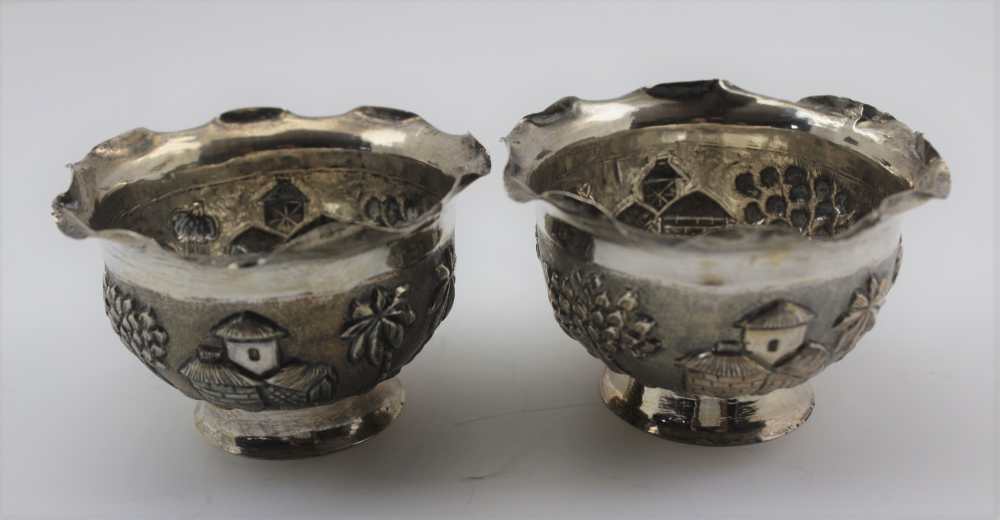 A PAIR OF EASTERN WHITE METAL SWEETMEAT BOWLS, repousse decoration in the round, landscape with palm