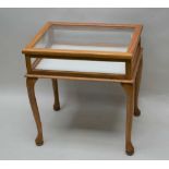 A 20TH CENTURY LIGHT OAK FRAMED BIJOUTERIE TABLE, glazed with lift-up lid, supported on four