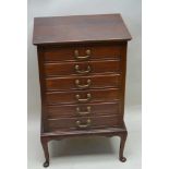 AN EARLY 20TH CENTURY MAHOGANY FINISHED SIX DRAWER MUSIC CABINET, with typical fall down fronts,