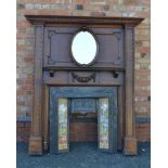 A 20TH CENTURY FIREPLACE, having fancy oak surround, with dentil cornice, insert oval bevelled plate