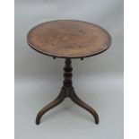 A 19TH CENTURY MAHOGANY CIRCULAR TILT TOP OCCASIONAL TABLE, on turned column and three downswept