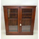 A MAHOGANY TWO-DOOR GLAZED BOOKCASE, of plain form, bearing the plaque "Dickson & Benson Ltd." of