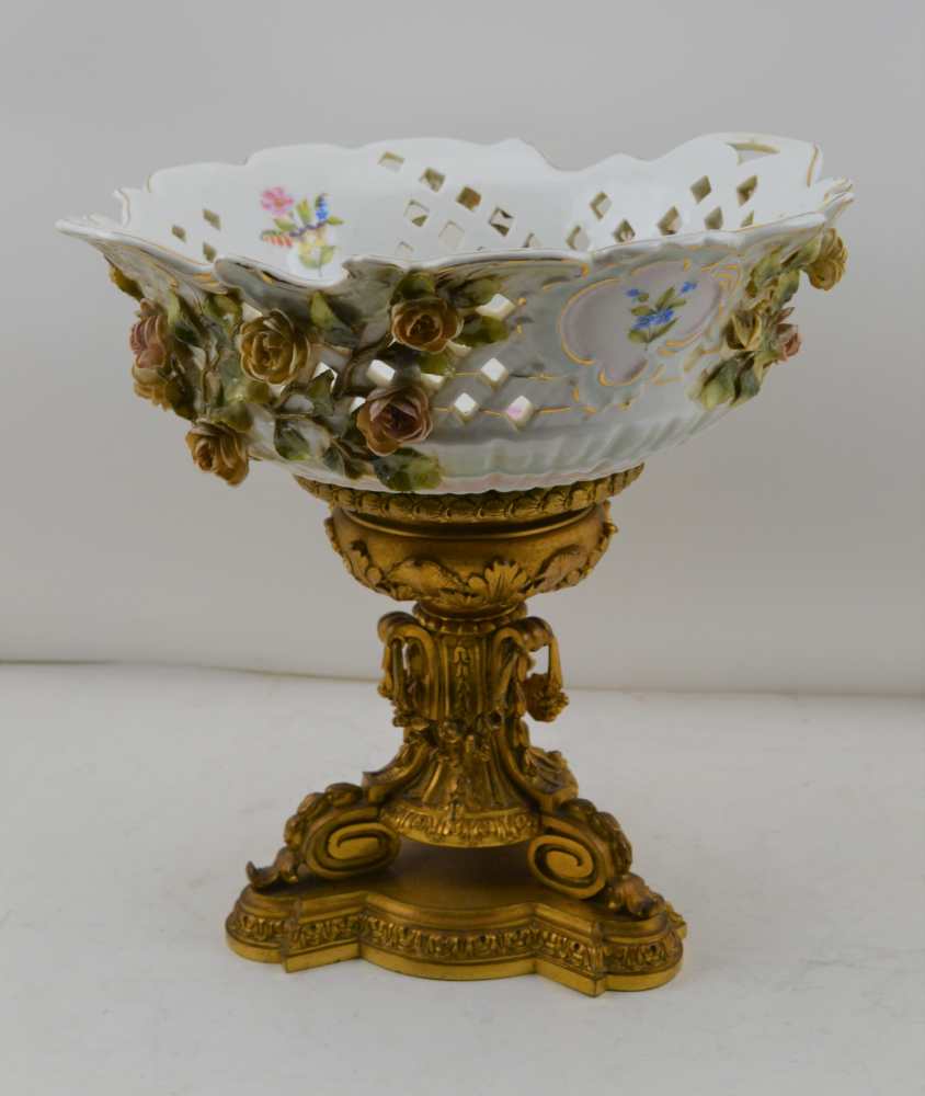 A CONTINENTAL CERAMIC BOWL upon a gilt brass base, the bowl with applied flowers, hand painted and