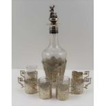 A CONTINENTAL LIQUEUR DECANTER & SIX SILVER HOLDERS, repousse decoration to the decanter base,
