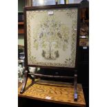 A GLAZED ARTS & CRAFTS STYLE TAPESTRY depicting flora & fauna, currently mounted as a firescreen