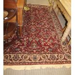 A MODERN MACHINE MADE RED GROUND FLORAL PATTERNED RUG