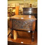 A CARVED OAK BOX TOP STOOL, on turned and block legs with fruit & vine panels, containing a