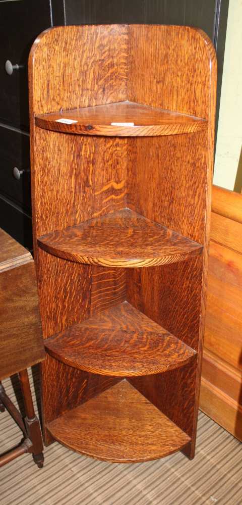 AN OAK FINISHED OPEN FRONTED GRADUATING SET OF CORNER SHELVES