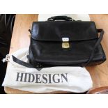 A BLACK LEATHER BRIEFCASE by "Hidesign", with dust bag