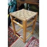 A BEECH FRAMED STRUNG TOPPED STOOL