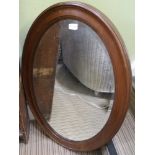 AN OVAL FRAMED BEVELLED PLATE WALL MIRROR