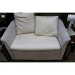 A WHITE PAINTED WOVEN WICKER TWO PERSON SETTEE