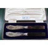 A PAIR OF HALLMARKED SILVER BLADED BUTTER KNIVES with hardstone handles, in a fitted Brook & Son