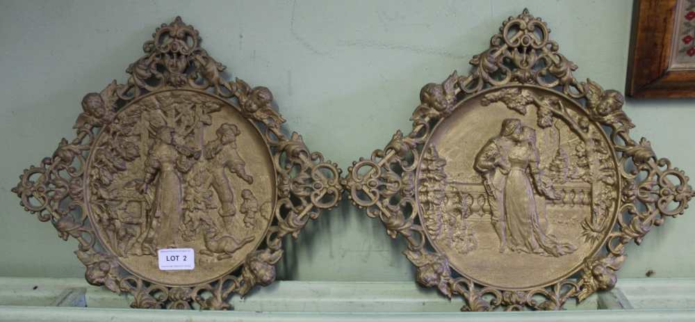 A PAIR OF GILT PAINTED CAST METAL PLAQUES depicting courtship scenes