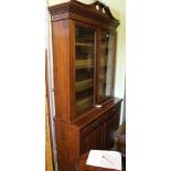 A LATE VICTORIAN WALNUT BOOKCASE, the base enclosed by a pair of raised and fielded panel doors over