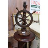 A WOODEN TABLE LAMP fitted with a revolving ships wheel