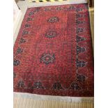 A SMALL SIZED WOVEN WOOLLEN FLOOR RUG on pigeon red ground