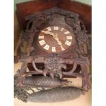 A BOX CONTAINING A CARVED WOODEN TYPICAL CUCKOO CLOCK with pendulum and weights