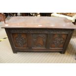 A REPRODUCTION OAK FINISHED SMALL SIZED COFFER with carved panel frontage