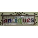 A SMALL DECORATIVE LEADED GLASS PANEL bearing the legend Antiques