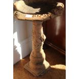 A TERACOTTA FINISHED FLORAL DECORATED BIRDBATH on pedestal column